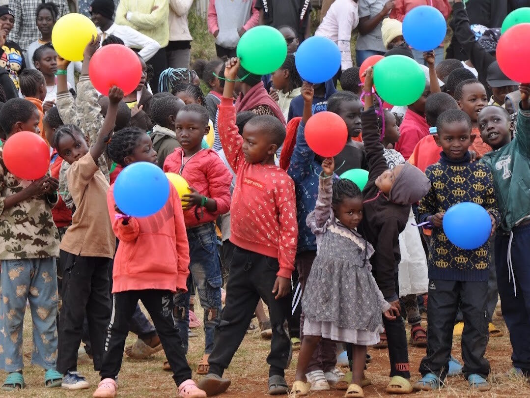Kinder mit bunten Luftballons beim Mentorship Camp