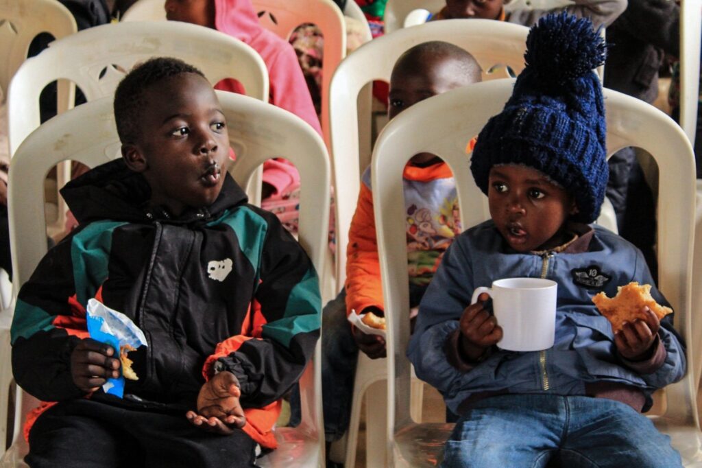 Kinder lassen sich das Essen bei einer Speisung schmecken